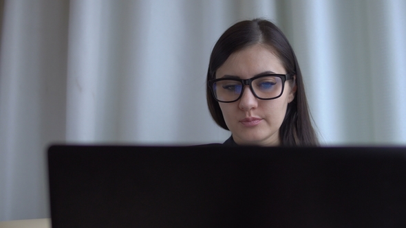 Young Brunette Businesswoman in Office Suit and Glasses Works with Laptop.