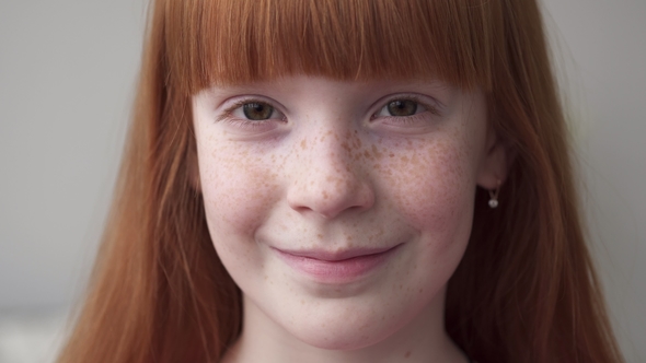 of a Face Little Ginger Girl with Freckles Smiling