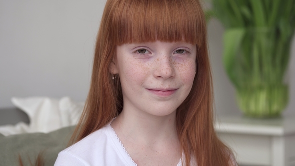 Little Happy Ginger Girl with Freckles in a White Room