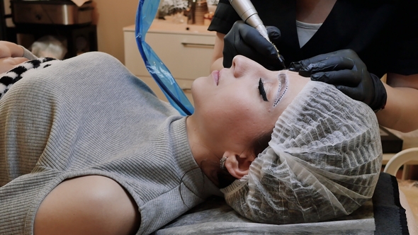 Permanent Tattooing of Eyebrows. Cosmetologist Applying Permanent Make Up alt