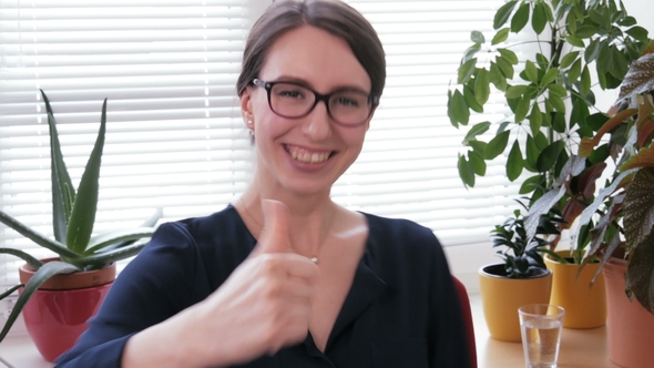 Well Done - a Laughing Businesswoman Shows the Thumbs Up Sign