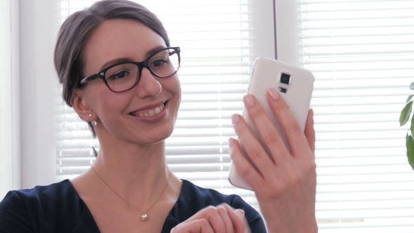 A Beautiful Businesswoman Using Phone and Smiling for a Selfie