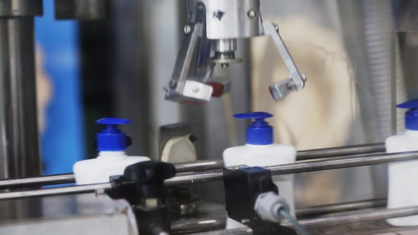 Automatic Robot Twists the Caps on a Conveyor Belt alt