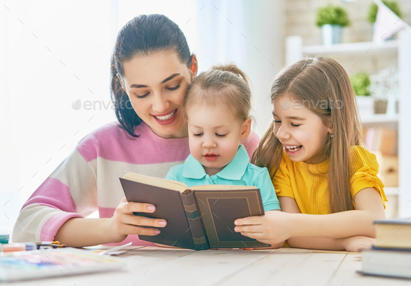 Mom and children reading a book - Stock Photo - Images