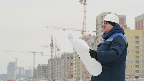 Foreman with Paper Drawing Plan at Construction Project