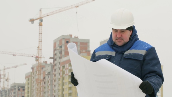 Foreman with Paper Drawing Plan at Construction Project