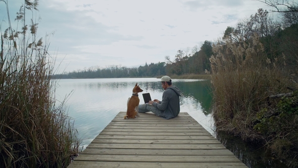 Freelancer Works on His Laptop Outdoor Next To Lake, Sitting on Pond