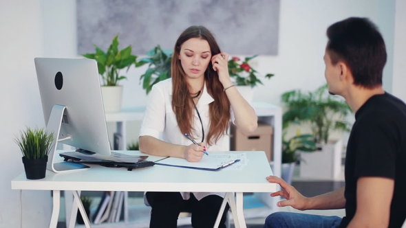 Beautiful Female Doctor Asks the Patient About the Disease
