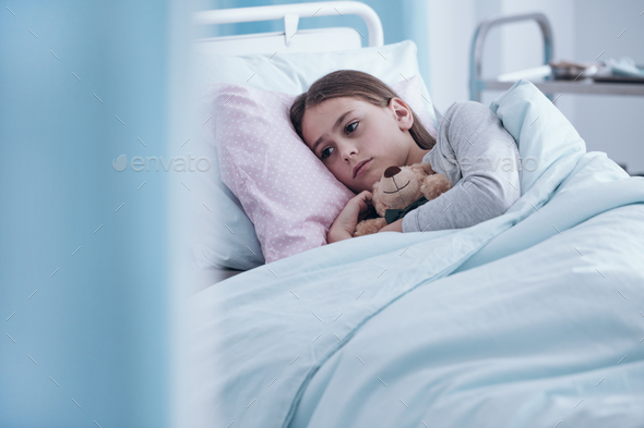 Sick girl in hospital bed - Stock Photo - Images