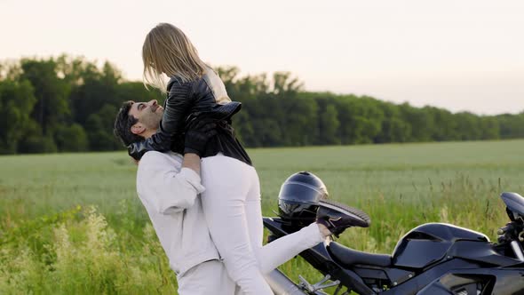 Beautiful Couple Meets Near Sport Motorcycle on the Road Near Field