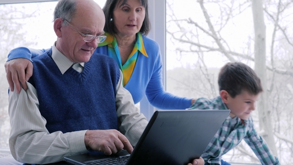 Happy Family, Grandparents with Grandchildren Play on Computer Near Big Window alt