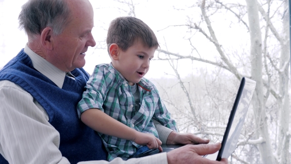 Preschool Home Education, Old Man with Child with Laptop in Hand Indoors alt
