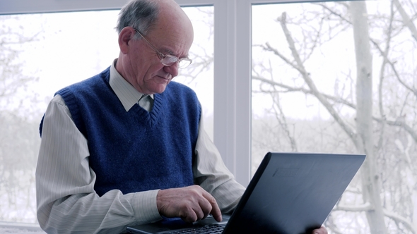Older Man and Woman with Laptop Spend Time on Internet on Vacation in Room alt