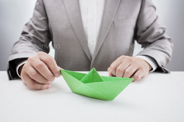 Businessman with a green paper boat - Stock Photo - Images