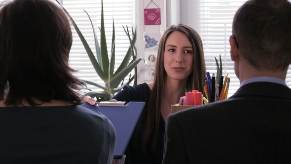 Well Done - Content Businesswoman Gives a Clipboard with a Project To Her Team