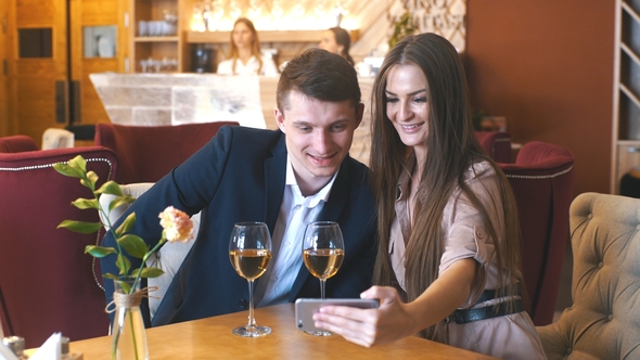 Happy Young Couple Taking Selfie with Smart Phone at Cafe