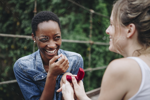 Woman proposing to her happy girlfriend outdoors love and marriage concept - Stock Photo - Images