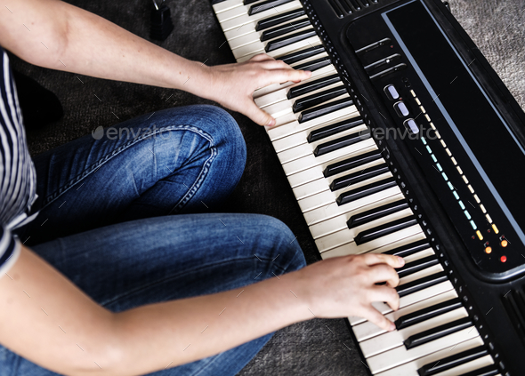 Practicing eletronic keyboard on the floor - Stock Photo - Images