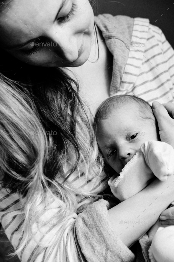 Young woman holding a newborn baby in her arms. Happy family. Black and white. - Stock Photo - Images