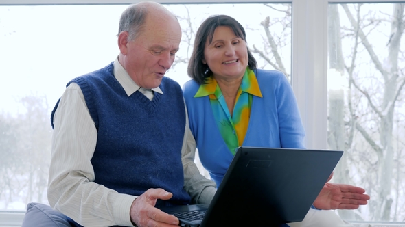 Payment Online Modern Old People, Happy Husband and Wife Talk in Skype with Computer at Home alt