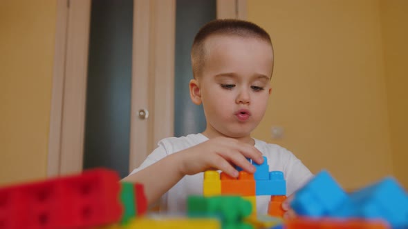 Funny Baby Boy Playing with Colorful Building Blocks Assembling Toy Bricks alt