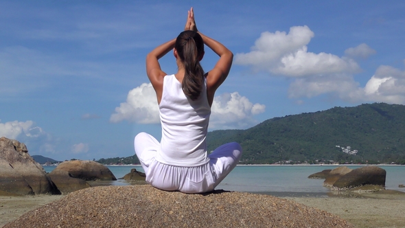 Young Woman Meditates at the Sea