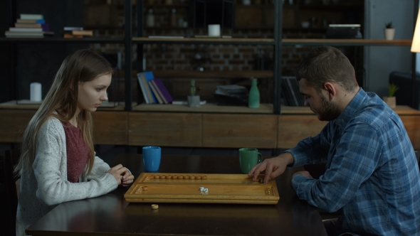 Young Attractive Couple Playing Backgammon alt