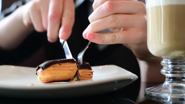 Teen Eating Eclair with Knife and Fork