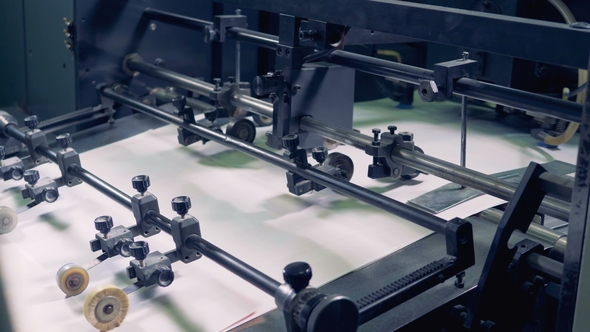 A Row of Paper Sheets Is Going Along the Factory Conveyor alt