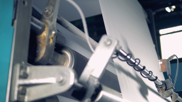 of Paper Moving Through Rollers of a Working Factory Machine alt
