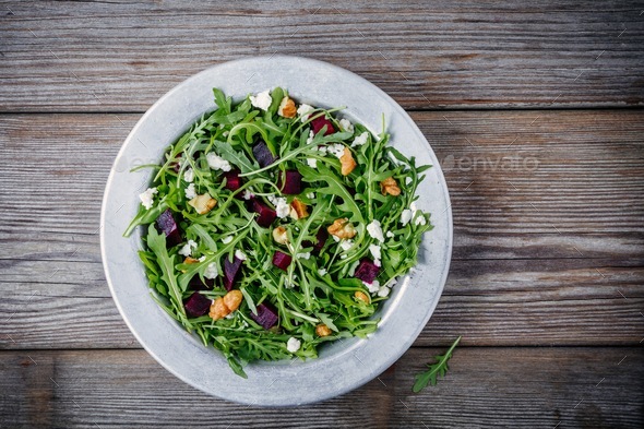 Fresh green salad with arugula, beets, walnuts and goat cheese Stock Photo by nblxer