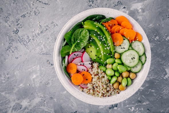 Vegan Buddha bowl with spinach, quinoa, chickpeas, grilled chicken, avocado, edamame, cucumbers - Stock Photo - Images
