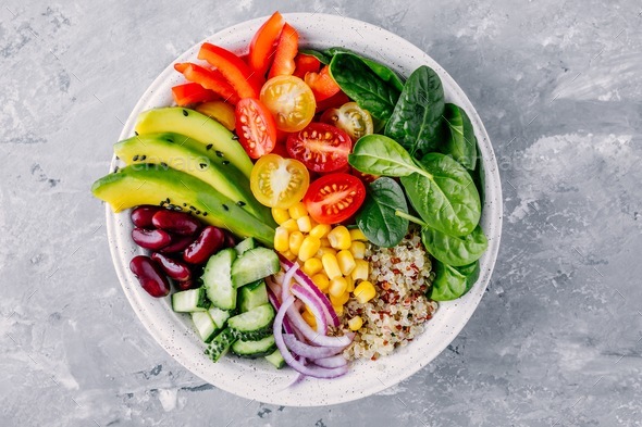 Healthy vegan lunch Buddha bowl. Avocado, quinoa, tomato, red beans, spinach salad. Stock Photo by nblxer