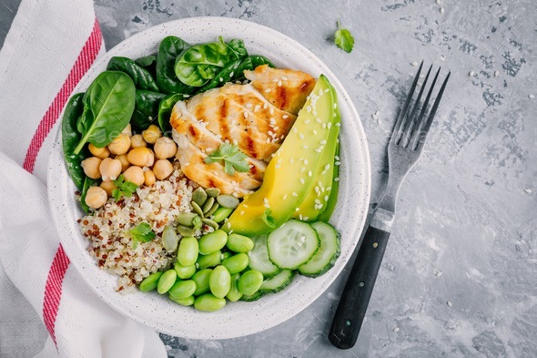 Buddha bowl with spinach, quinoa, chickpeas, grilled chicken, avocado, edamame beans, cucumbers - Stock Photo - Images