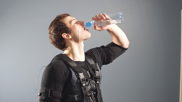 Fit Man Wearing Electro Stimulation Suit Drink Water After Training. alt
