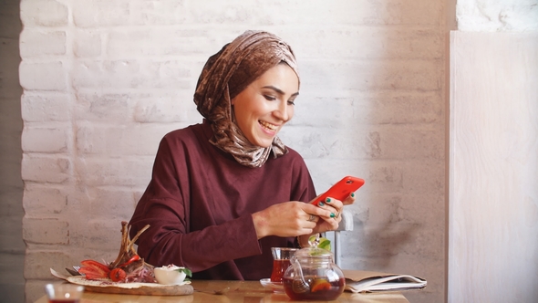 Happy Muslim Woman Using Mobile Phone. alt