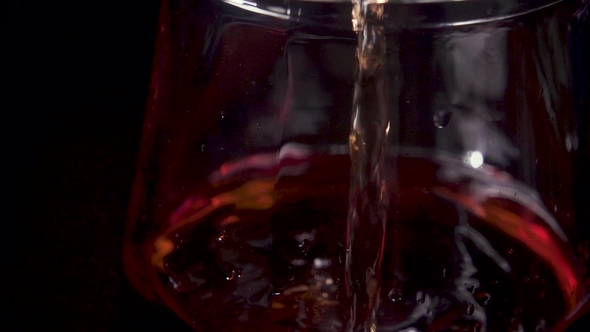 Stream of Wine Is Poured Onto the Decanter Glass and Bubbles