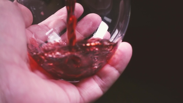Man's Hand Rotates a Glass of Wine