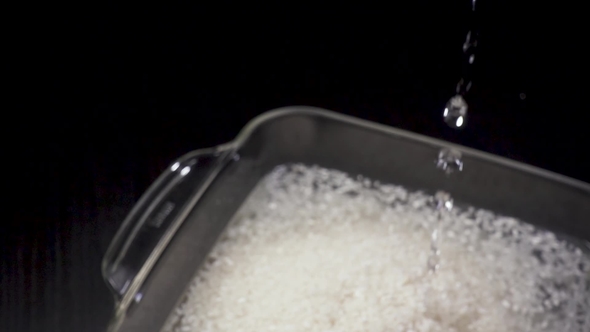 Water Is Poured Into a Bowl of Rice