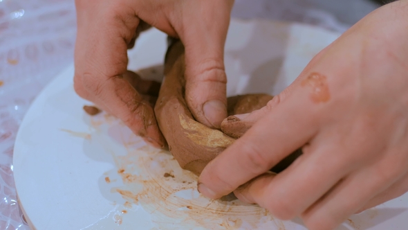 Professional Male Potter Making Mug in Pottery Workshop