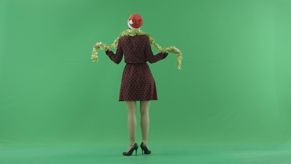 A Young Christmas Woman Is Circling Under the Snowfall on the Green Screen