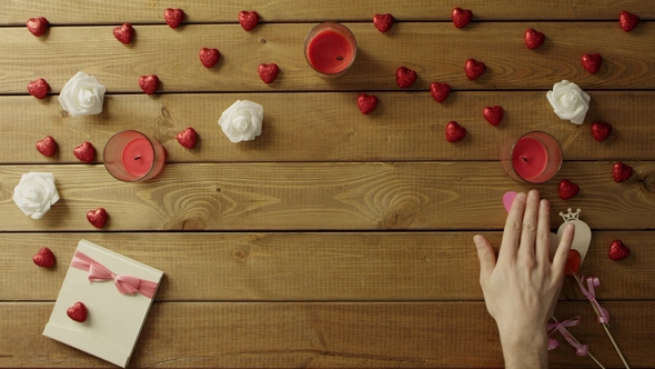 Man with Paper Heart Sits By Decorated Wooden Desk, Top View alt