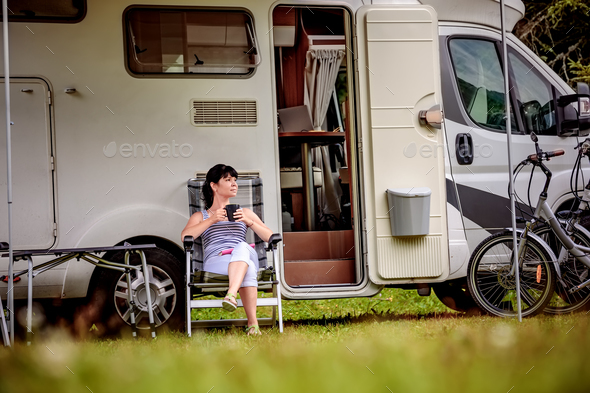 Woman is standing with a mug of coffee near the camper RV. - Stock Photo - Images