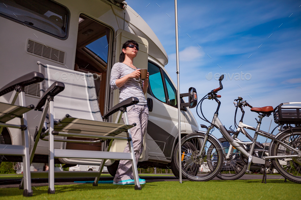 Woman is standing with a mug of coffee near the camper RV. - Stock Photo - Images