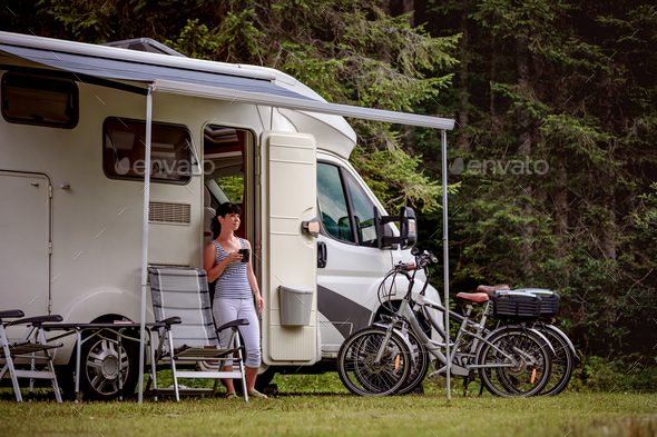Woman is standing with a mug of coffee near the camper RV. - Stock Photo - Images