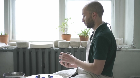 Portrait of Ceramist, Who Is Finishing His Work on Mug in Bright Studio. alt