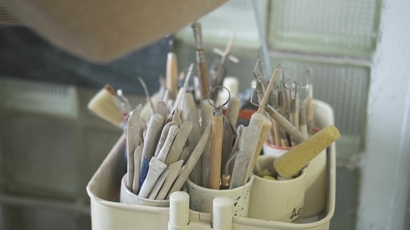 Young Woman Is Taking Tassels in Pottery Workshop. alt