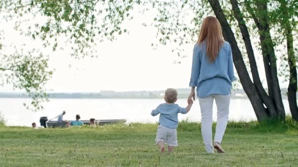 Mother and Toddler Watching Boat on Lake alt