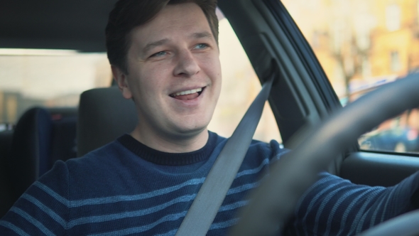 A Young Man Is Driving a Car and Singing