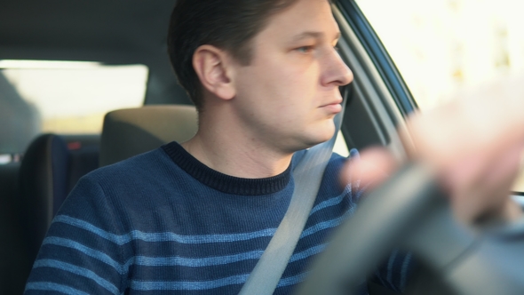 A Young Attractive Man Is Riding a Car While Driving